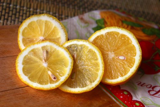 Close-up of juicy lemon slices on a wooden board, showcasing their vibrant texture and freshness.
