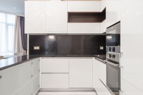 Free Sleek and clean modern kitchen with minimalist white cabinetry and black accents. Stock Photo