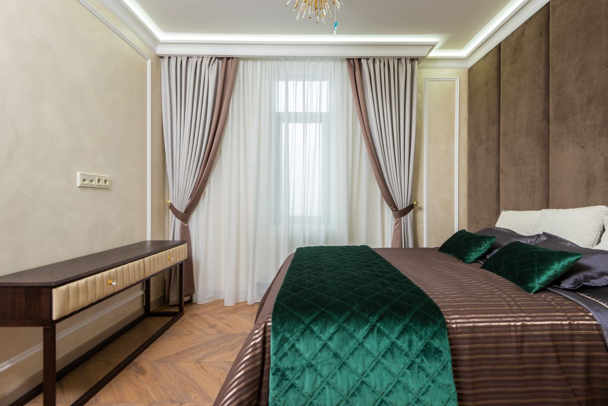 Sage green bedroom with wooden furniture