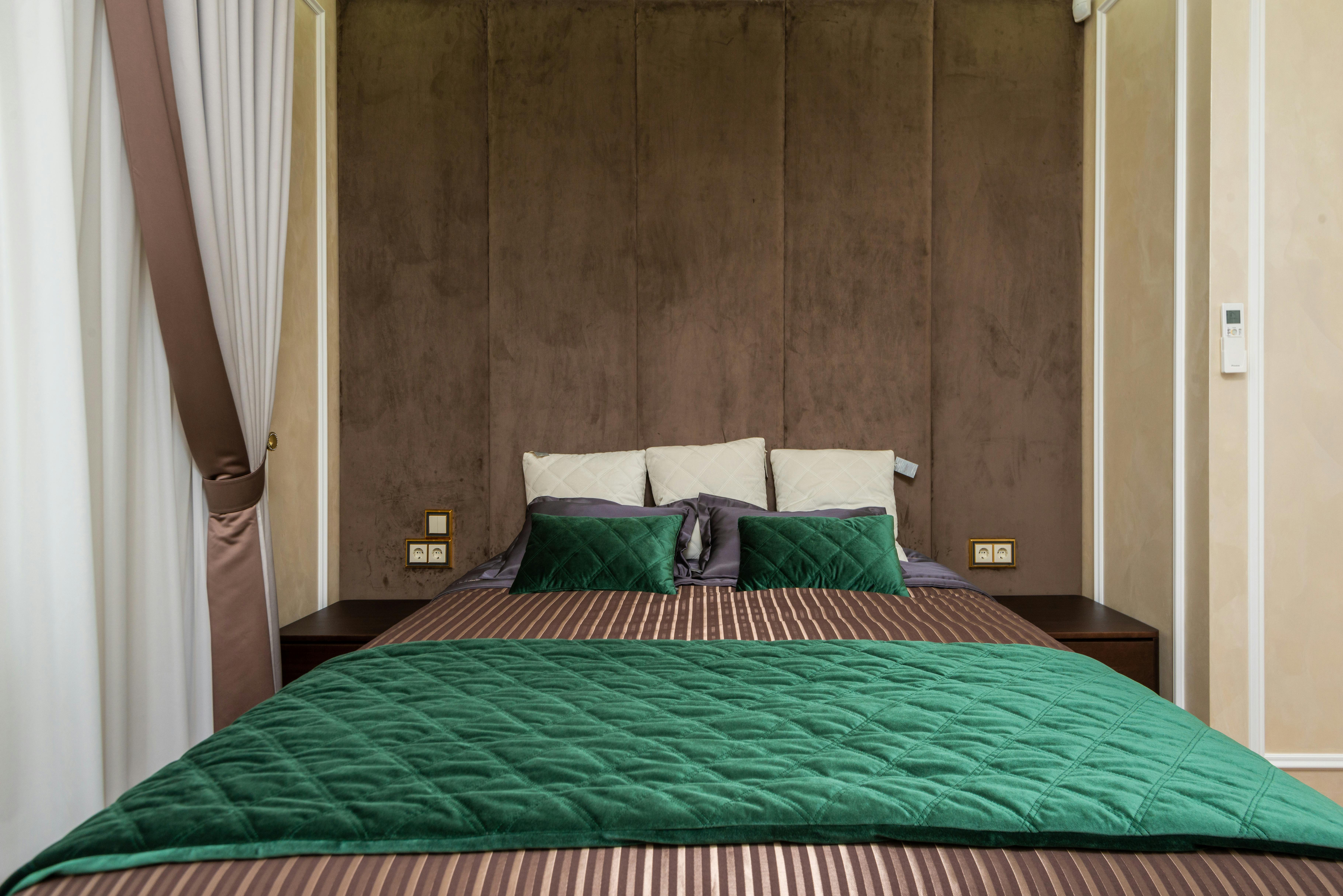 Cozy modern bedroom with green bedding and soft lighting. Ideal for contemporary design inspiration.