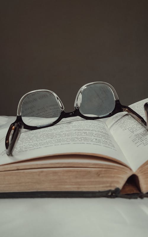 Free Black Framed Eyeglasses on Top of a Book  Stock Photo