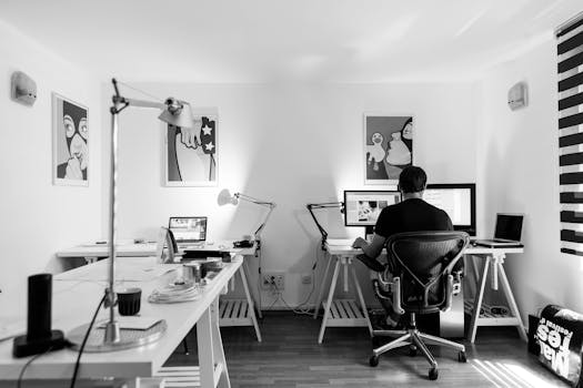 Grayscale Photography of a Man Sitting Infront of a Computer