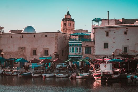 Charming waterfront view in Bizerte, Tunisia with boats and historical architecture.
