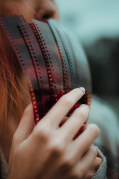 Beautiful close-up of a hand holding a film strip, showcasing artistic nostalgia.
