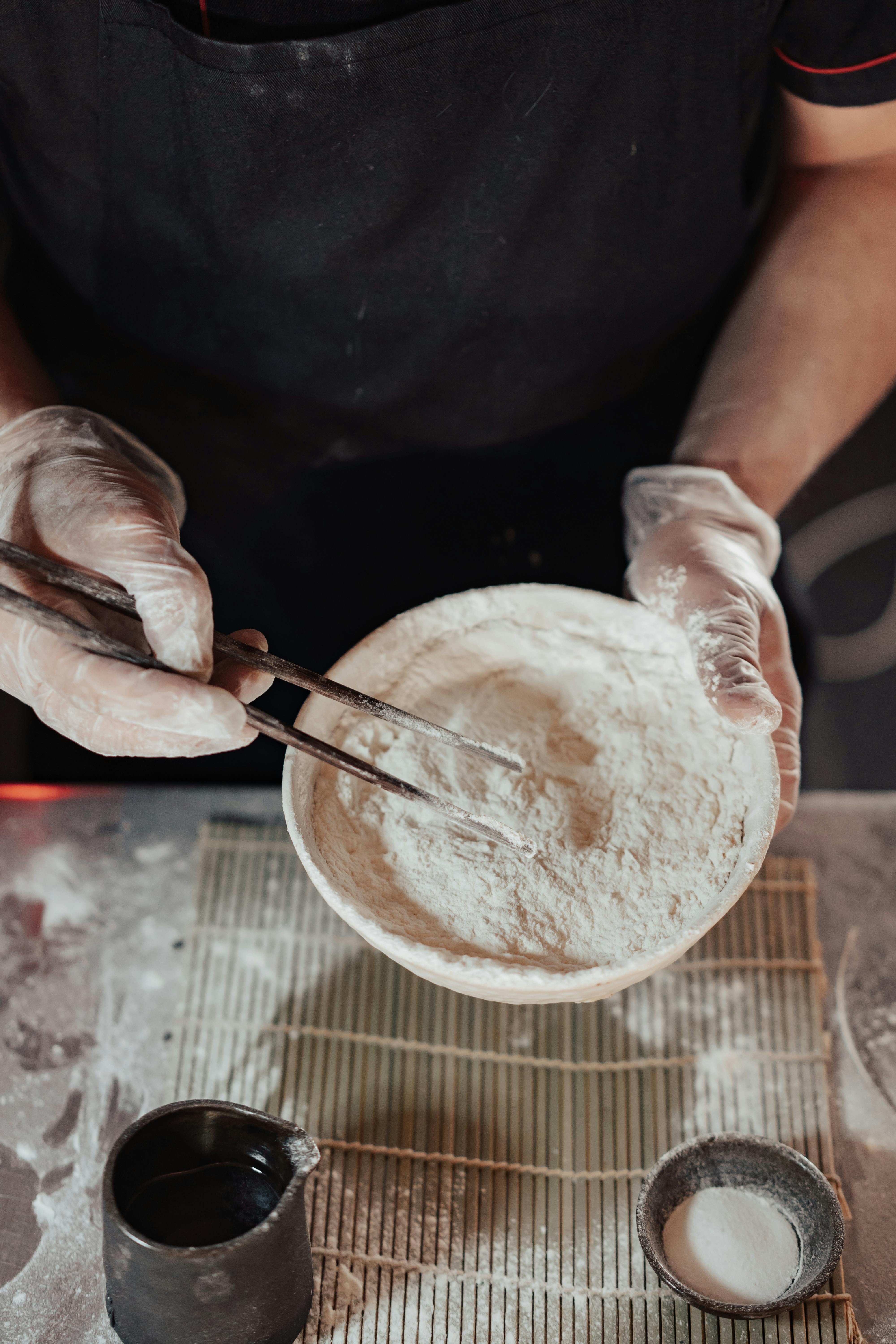 person holding white ceramic bowl with white powder