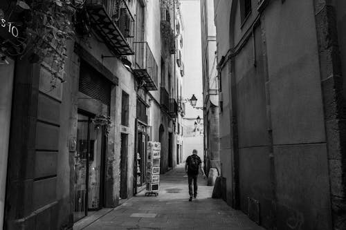Grayscale Photo of Man Walking on Street