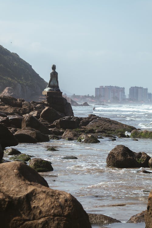 Statue on Rocks on Sea Shore