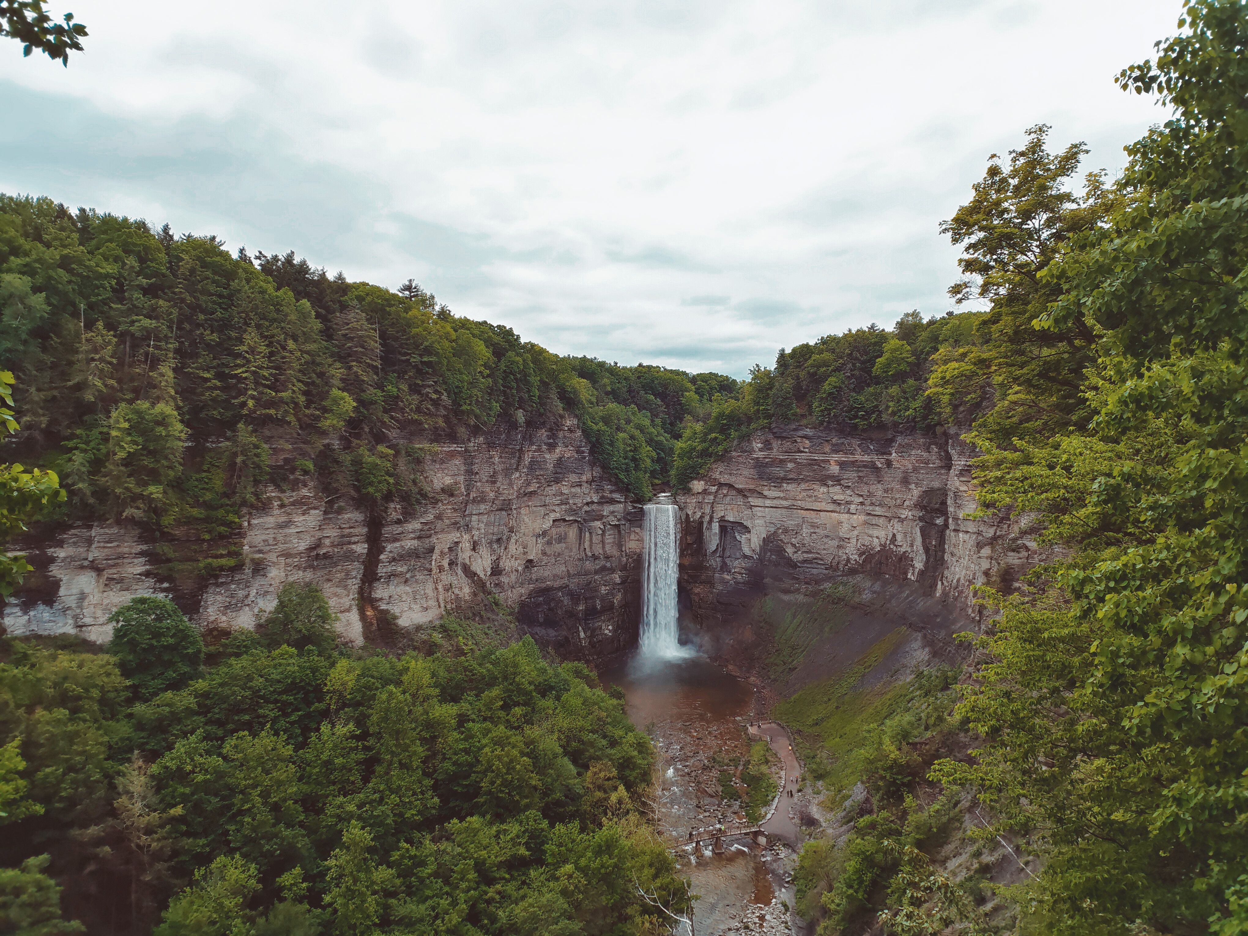 Wli Waterfalls cascading down a cliff face with lush green forest surrounding it