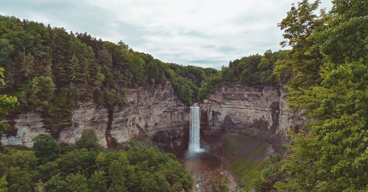 Wli Waterfalls cascading down a cliff face with lush green forest surrounding it