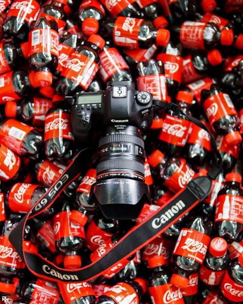 Free A Canon Camera on a Pile of Coca Cola Drinks Stock Photo
