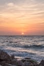 A Sun Setting Over an Ocean with Splashing Waves