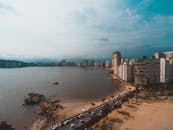 从多云的天空俯瞰，城市海滨的天际线令人惊叹，沙滩和平静的海水尽收眼底