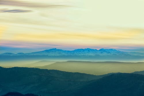 Aerial View of Mountains Under White Clouds