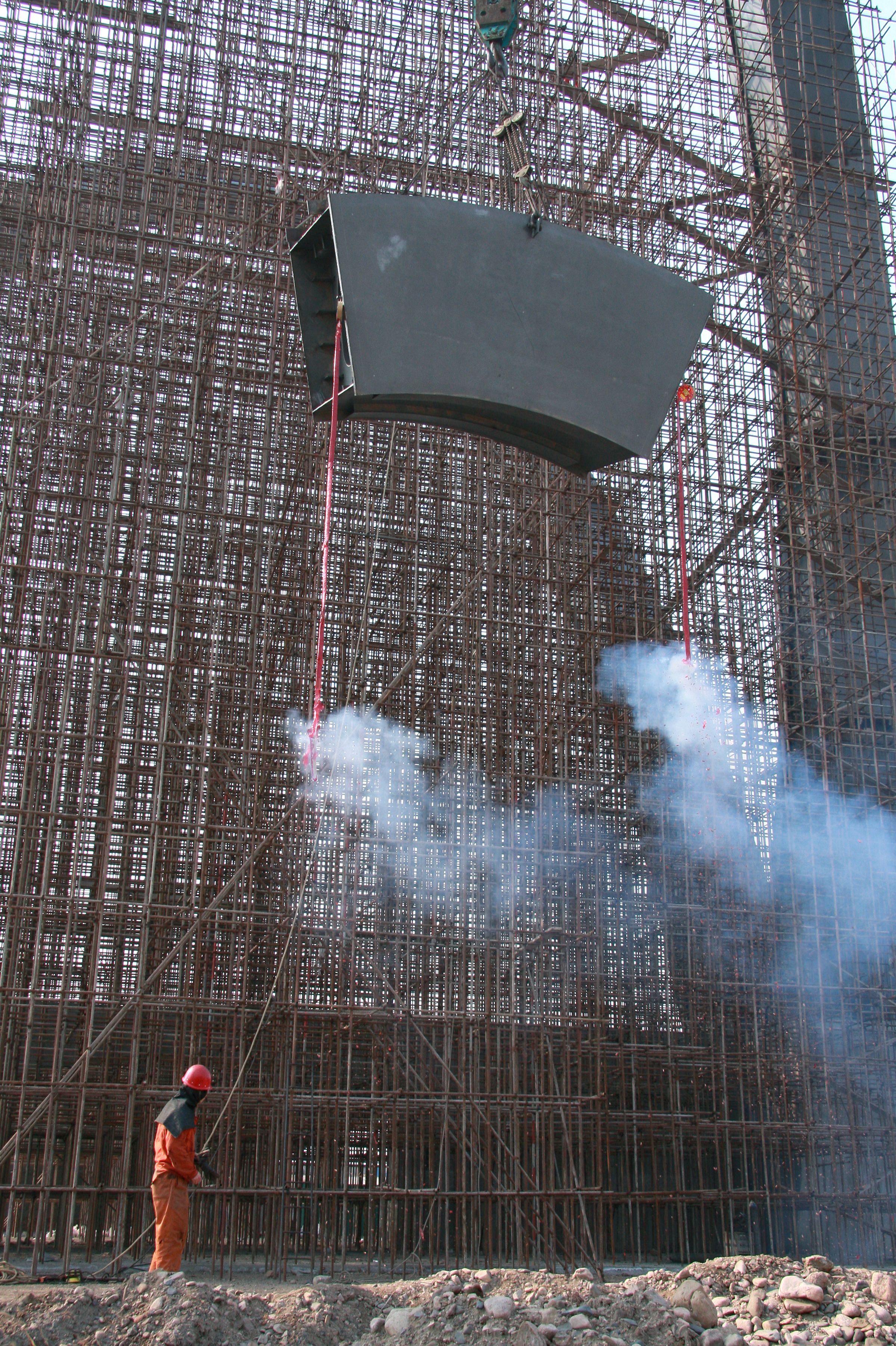 Construction worker supervising a steel beam placement on site