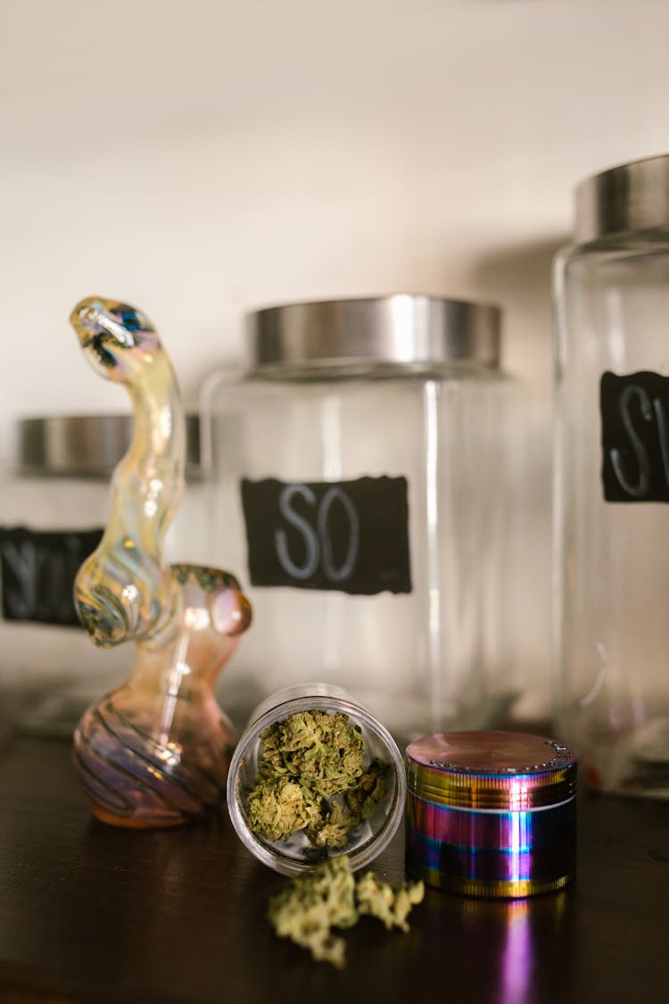 Cannabis In A Container Beside A Grinder