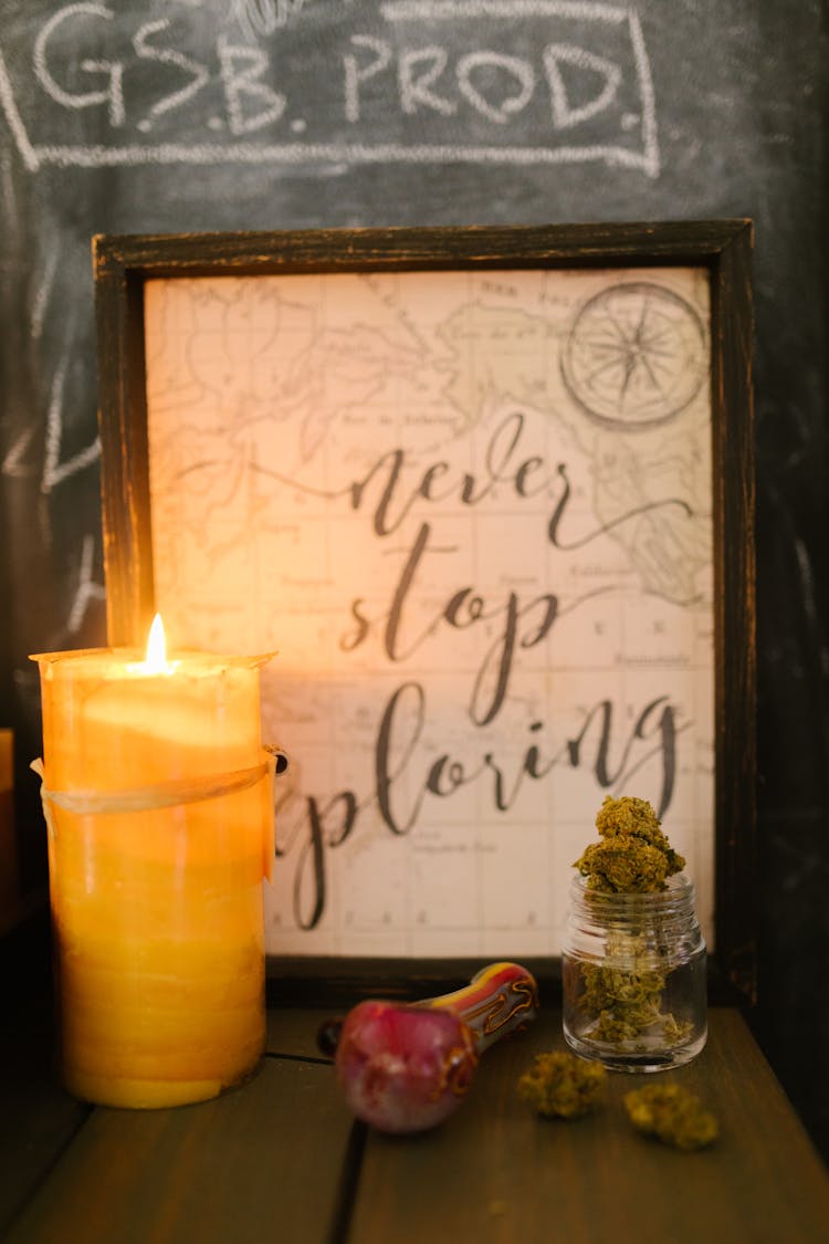 Lighted Candle In Front Of A Framed Paper Map