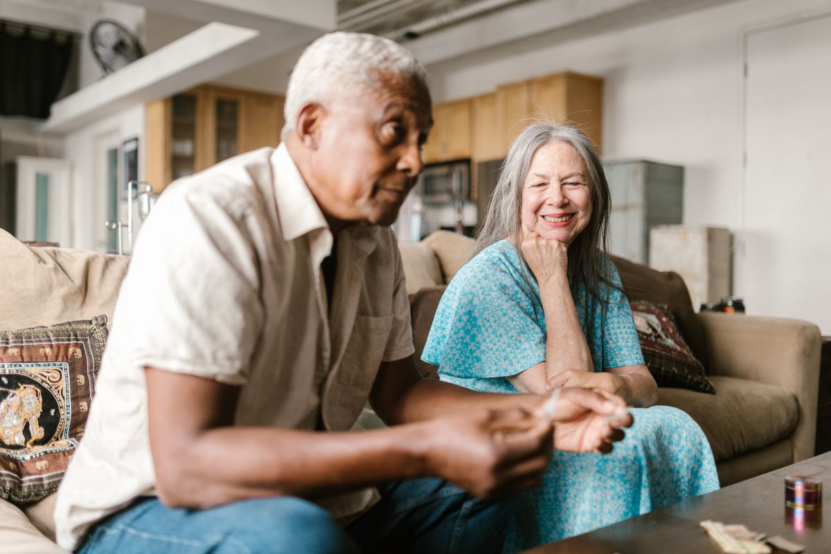 Older couple smiling and relaxing together on a sofa at home