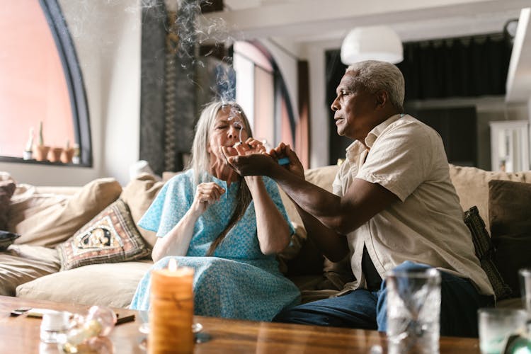 An Elderly Couple Smoking In The Living Room