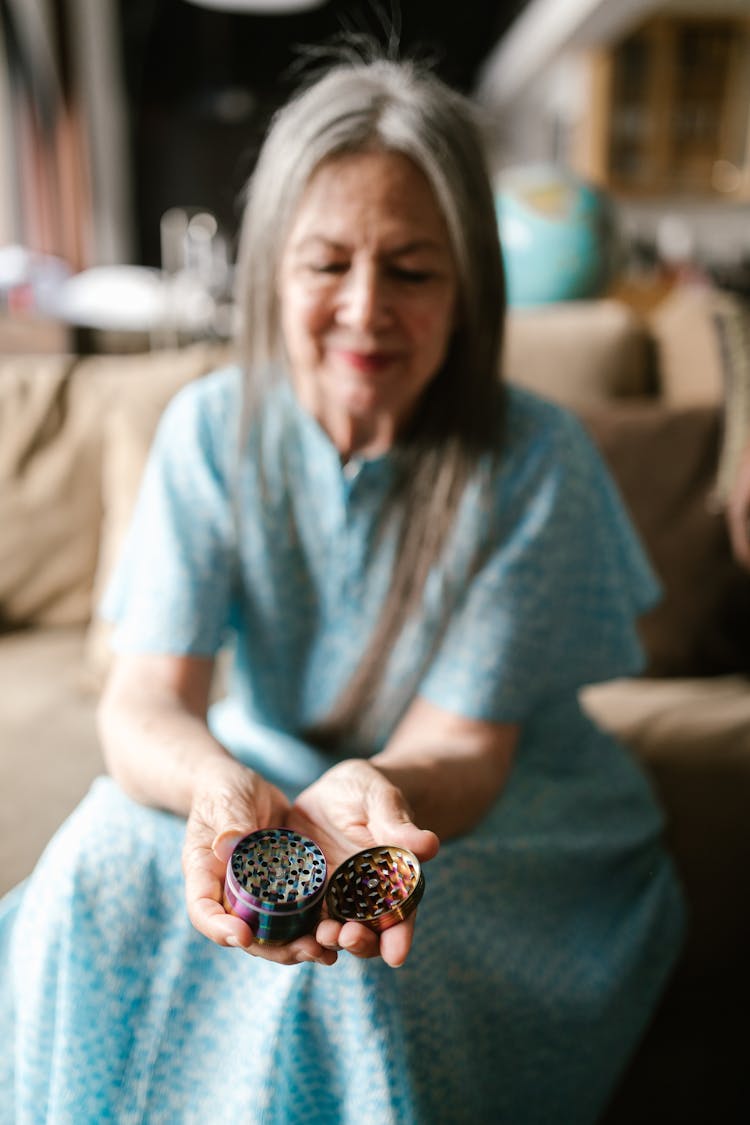 An Elderly Woman Holding A Weed Grinder