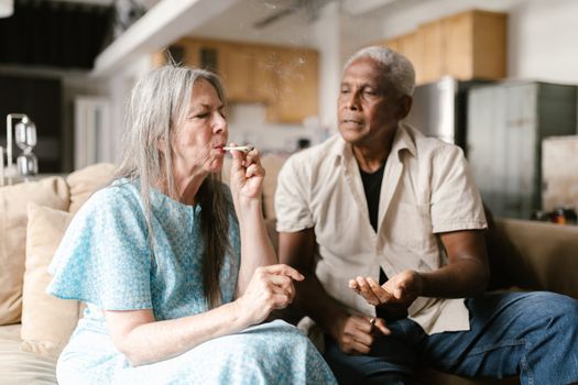 Senior adults sharing a moment with medical marijuana indoors.