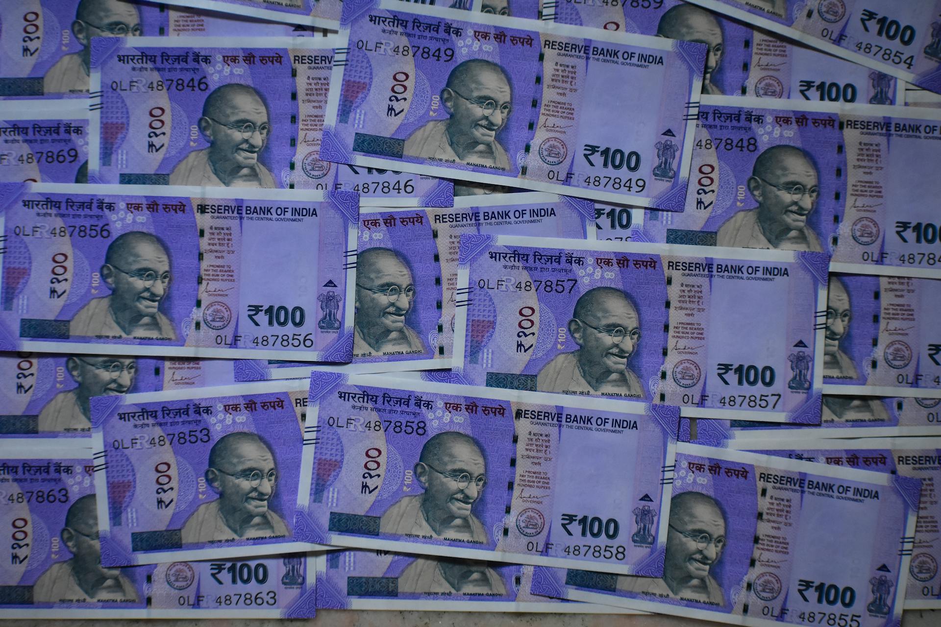 Detailed view of 100 Indian rupee notes featuring Mahatma Gandhi, symbolizing prosperity and economy.