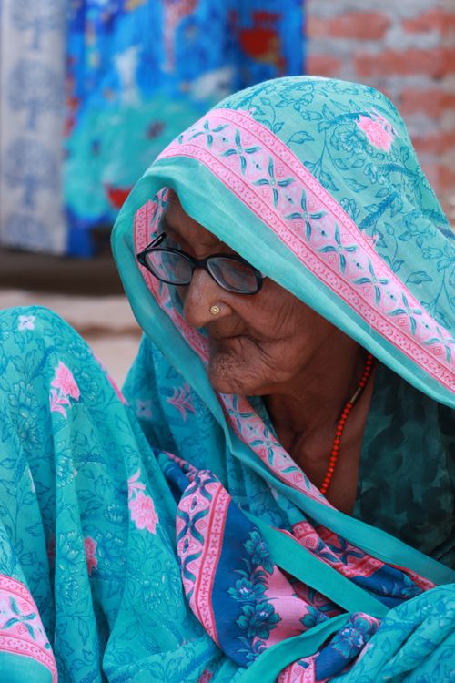 Free Side view of a senior woman in a colorful sari and hijab, portraying cultural elegance. Stock Photo