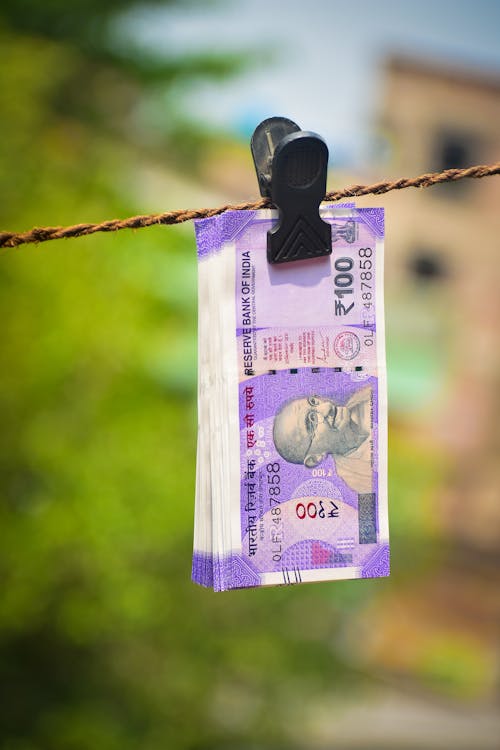 Close Up Photo of Indian Bank Notes Clipped on Rope