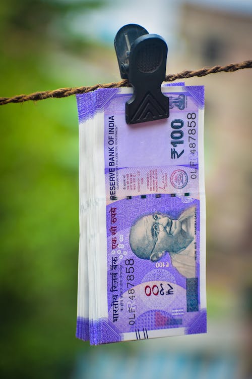 Close Up Photo of Indian Bank Notes Clipped on Rope