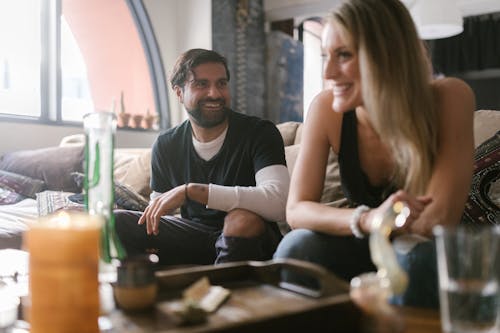 A Man and Woman Having Conversation while Sitting on the Couch