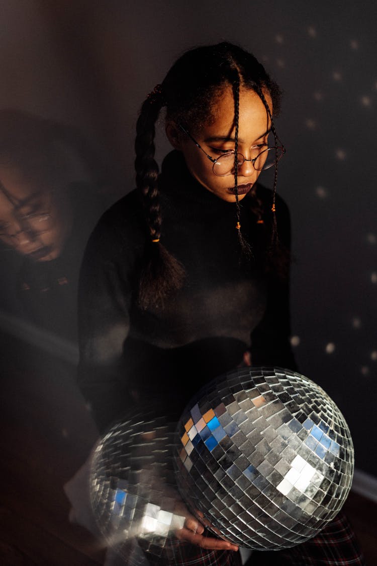 Girl In Her Black Sweater Holding A Mirror Ball