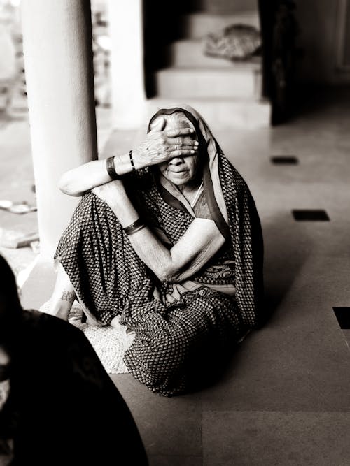 Gray Scale Photo of Woman Seat on Floor