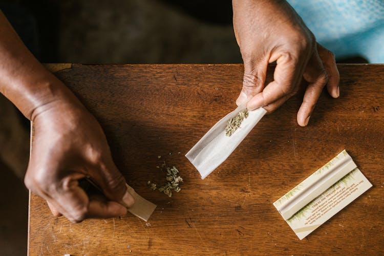 High-Angle Shot Of A Person Rolling A Marijuana