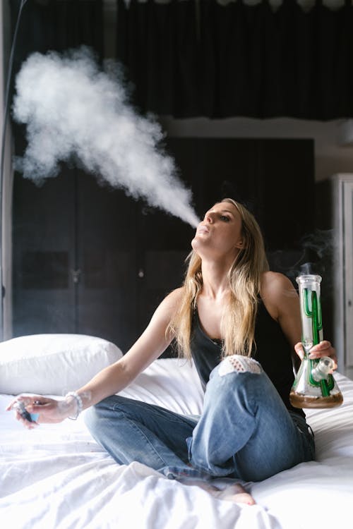 Free A Woman Using a Bong on the Bed  Stock Photo