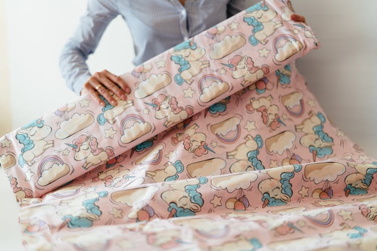 Close-up Of Woman Folding A Fabric With A Cute Unicorn Print 