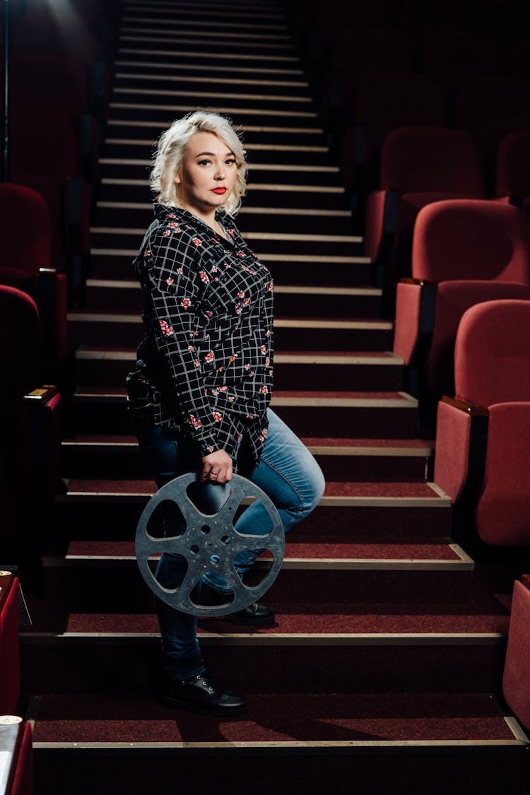 Woman With Film On Stairs In Movie Theater