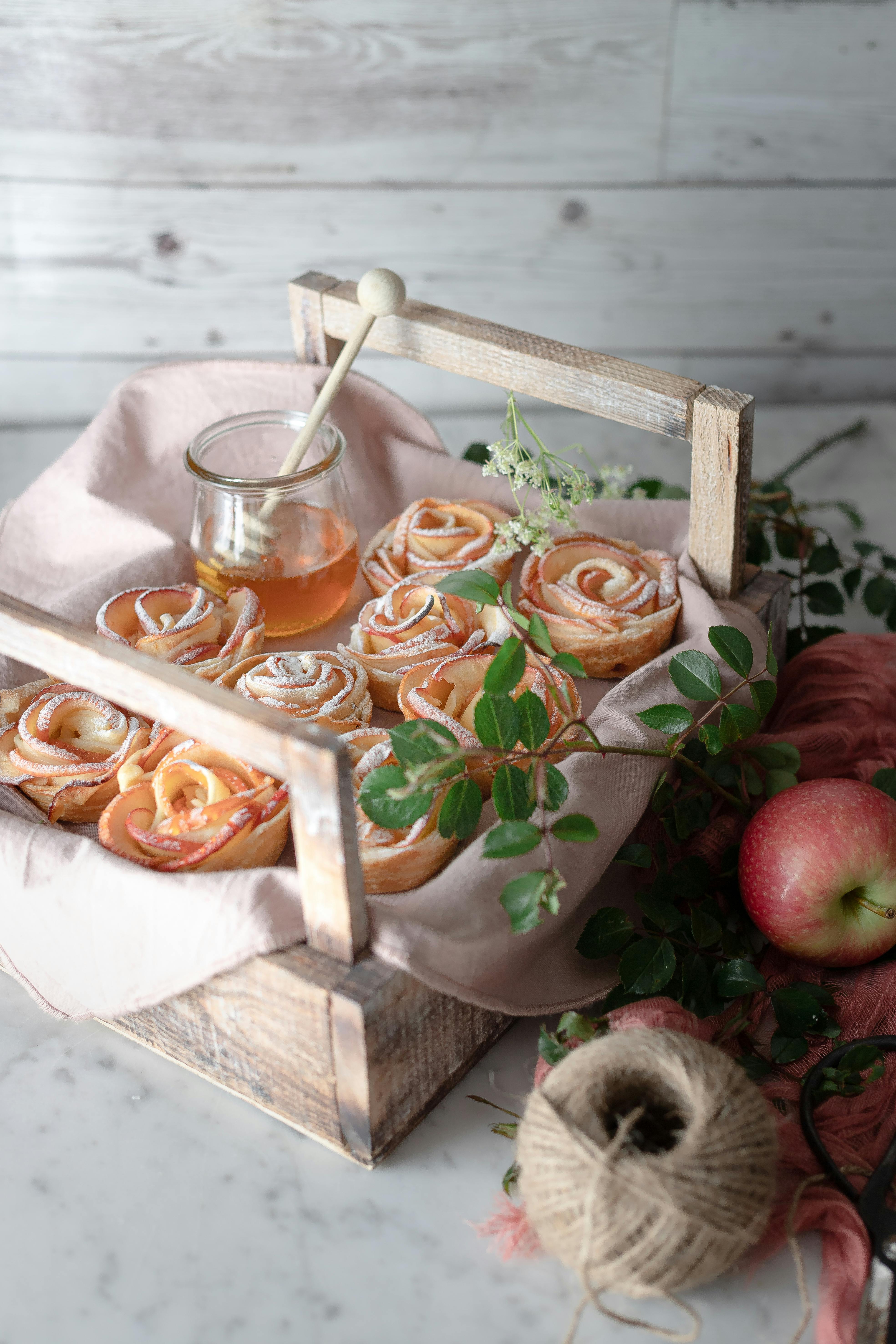 Delicious apple rose pastries elegantly displayed with honey jar, perfect for dessert lovers.