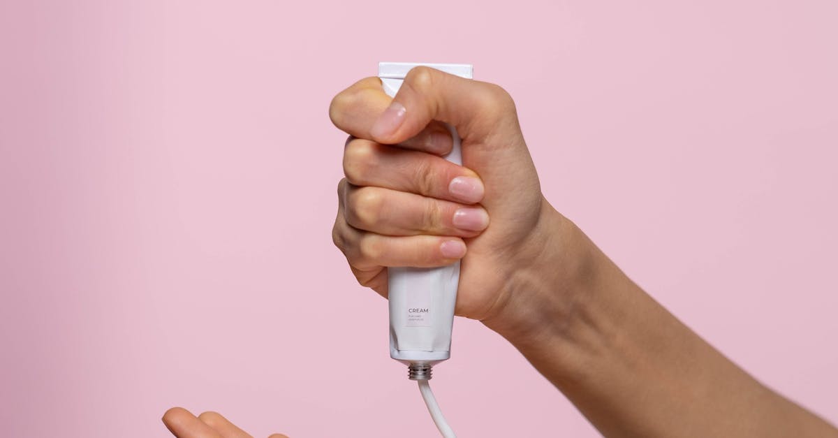 A woman applying hydrating face cream in front of a mirror.