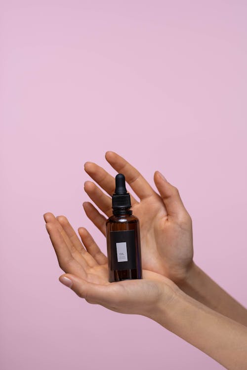 Free Person Holding A Bottle Of Serum Stock Photo