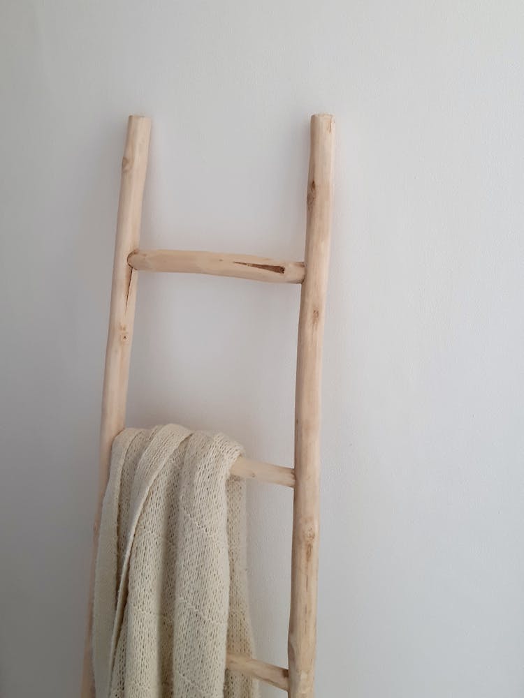 White Towel Hanging On Wooden Ladder