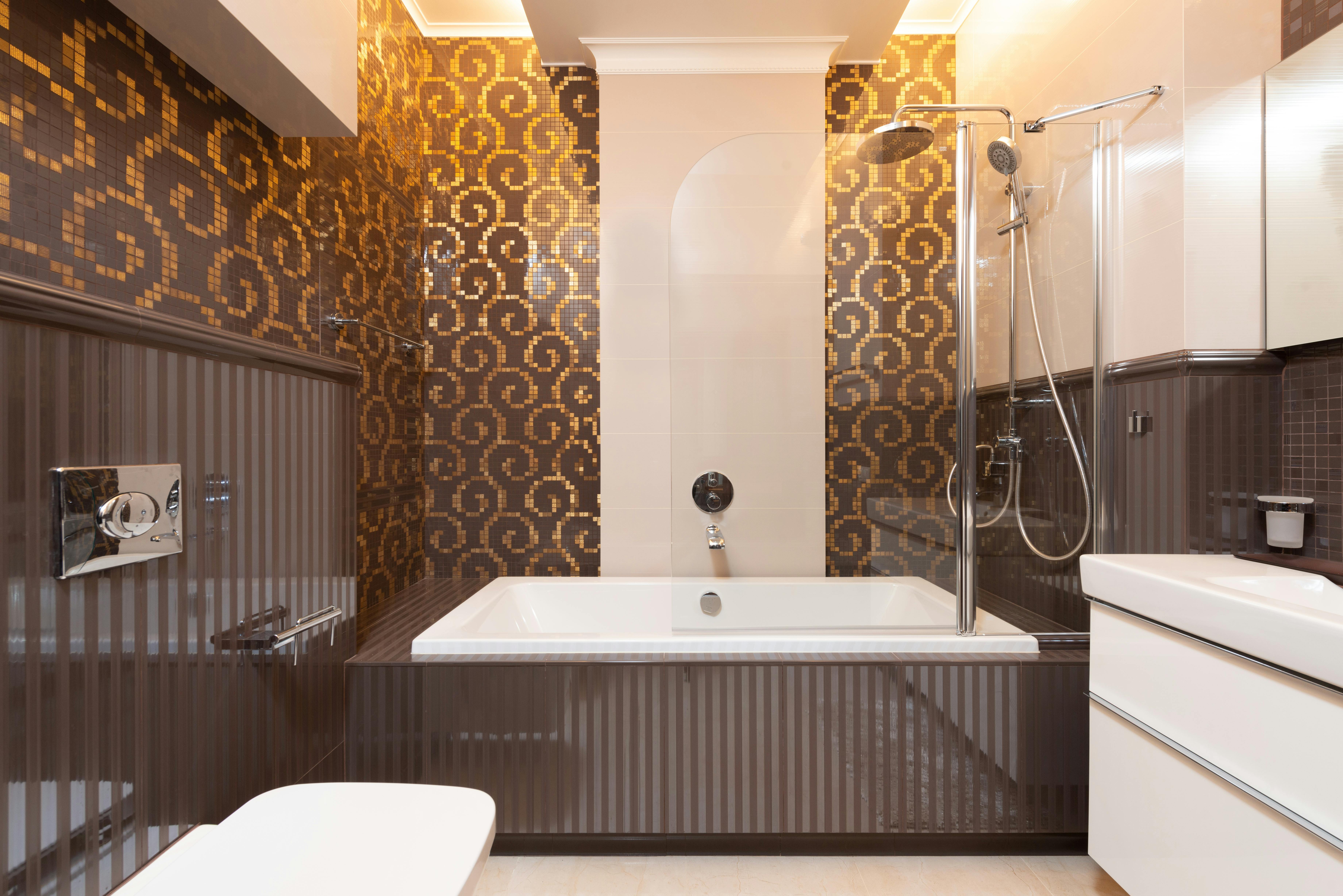 Metallic Gold Bathroom Tiles With Accents And Inserts In A Neutral Bathroom Setting