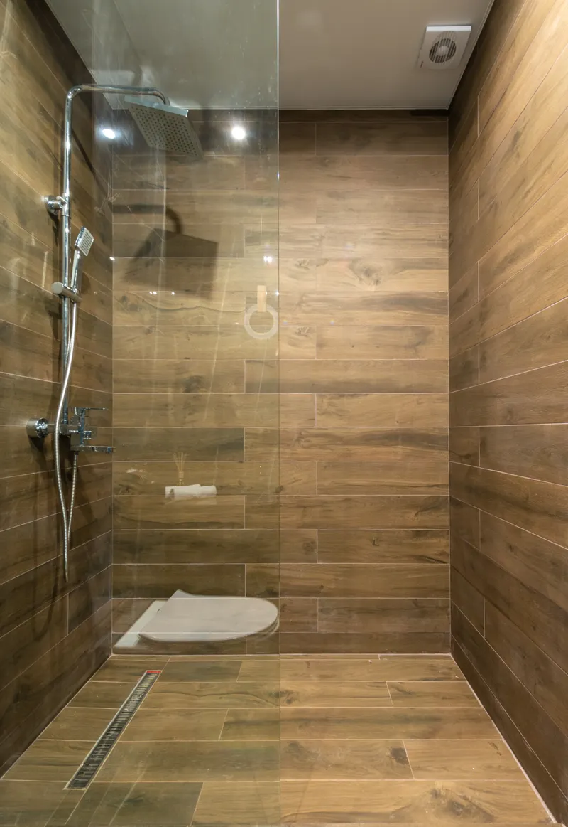 Modern spacious walk-in shower with glass partition