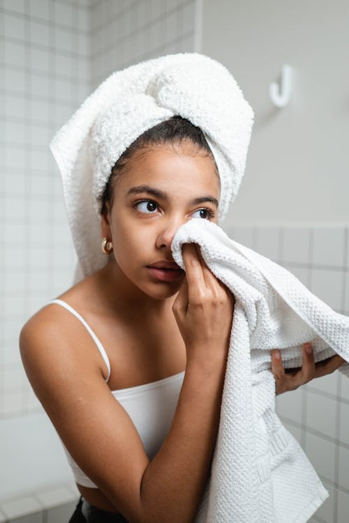 Free Woman in White Tank Top Wiping Her Face With Towel Stock Photo