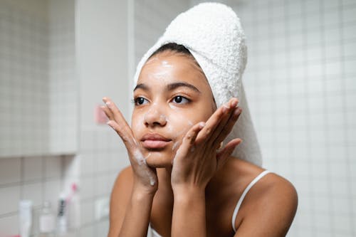 Woman in White Tank Top Covering Her Face With White Towel