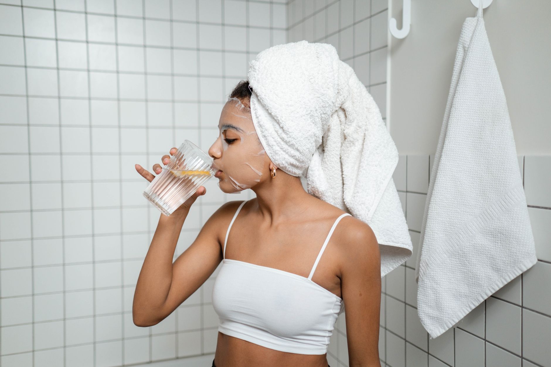 A woman sipping water in a spa, emphasizing hydration during wellness.