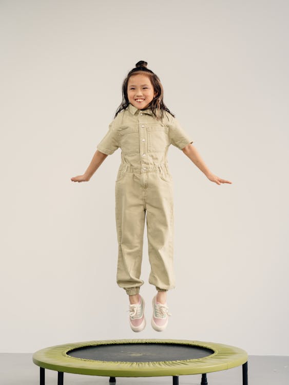 Free A Happy Little Girl Jumping on a Trampoline Stock Photo