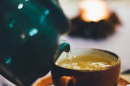 Personne Versant Du Liquide Dans Une Tasse En Céramique Brune