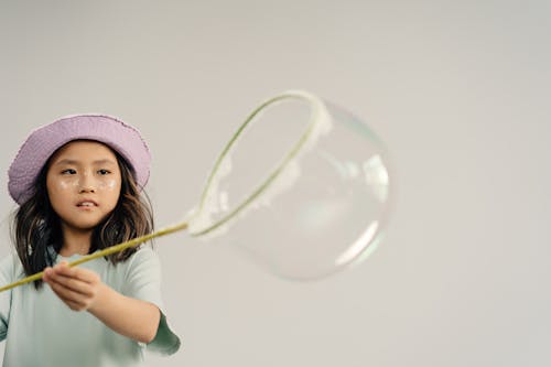 Free Young Girl Playing a Bubble on White Background Stock Photo