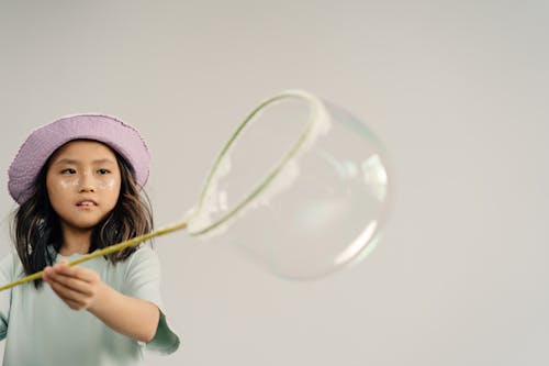 Young Girl Playing a Bubble on White Background