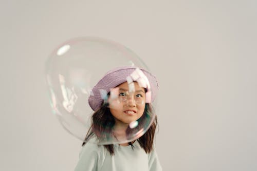 Young Girl Playing a Bubble on White Background