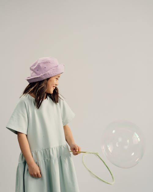 Free Young Girl Playing a Bubble on White Background Stock Photo